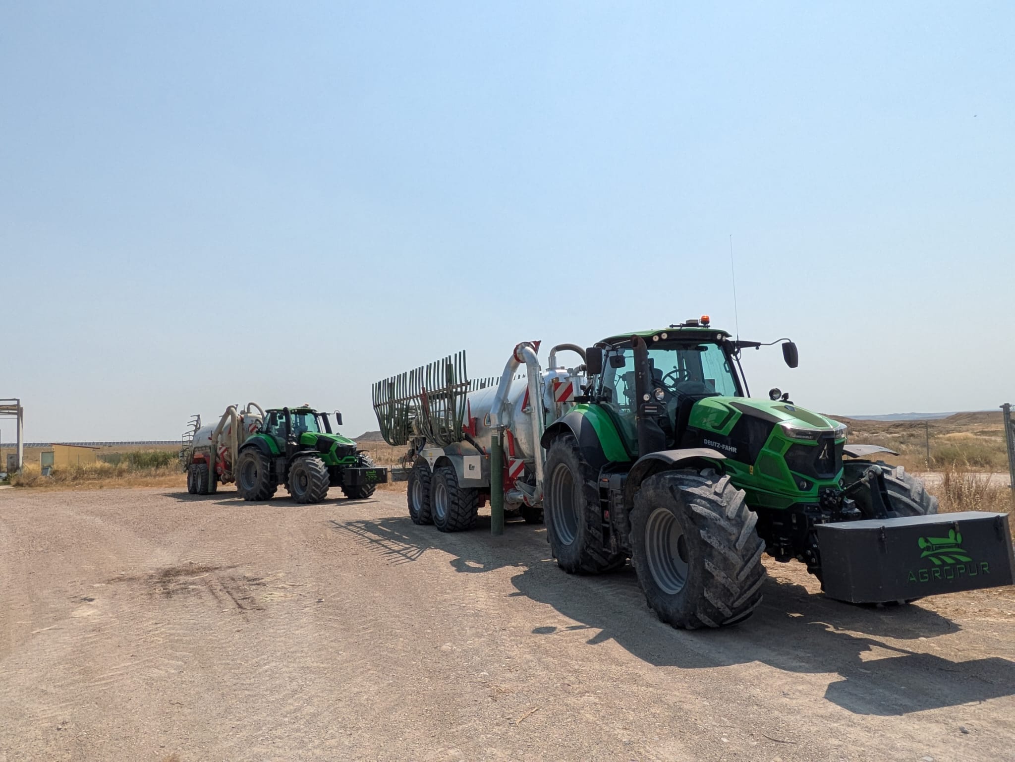 Vista aérea de balsa de purín con tractores Agropur y naves ganaderas